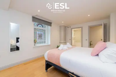 a bedroom with a large bed with pink pillows at High Quality 2 Bedroom Church Apartment 5 Mins to Town Centre - Free Parking in Shrewsbury