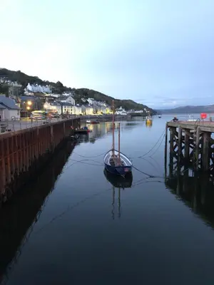 a sail boat in the water next to a dock at Tŷ Treflan in Aberdyfi