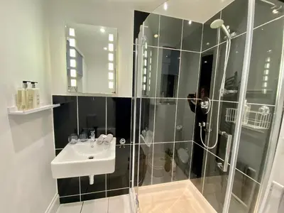 a person taking a picture of a bathroom with a shower at Tŷ Treflan in Aberdyfi