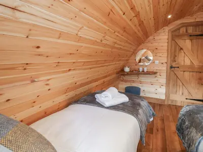 a log cabin with a bed in a room at Buttercup in Rhayader
