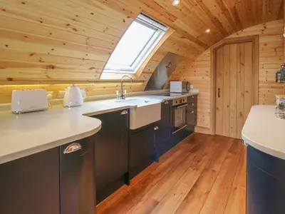 a kitchen with a large sink and a window at Buttercup in Rhayader