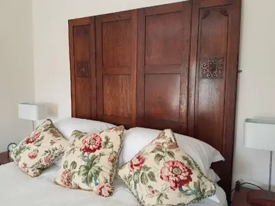 a bed with pillows on it with a wooden headboard at Upper Buckton B&B in Leintwardine