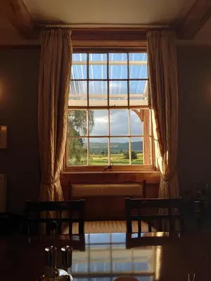 a window in a room with a table and two chairs at Upper Buckton B&B in Leintwardine