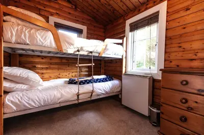 two bunk beds in a log cabin with a window at Stunning Log Cabin with Garden in Snowdonia - Hosted by Seren Short Stays in Trawsfynydd
