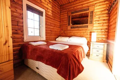 a bedroom with two beds in a log cabin at Stunning Log Cabin with Garden in Snowdonia - Hosted by Seren Short Stays in Trawsfynydd