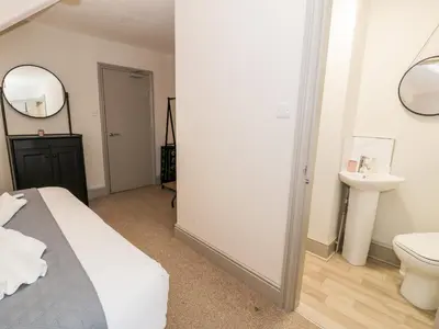 a bedroom with a bed and a sink and a mirror at Rose Suite in Barmouth