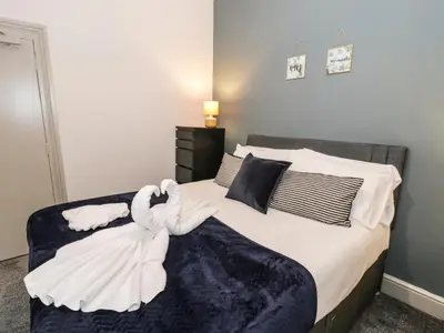 a bedroom with a bed with white towels on it at Sapphire Suite in Barmouth
