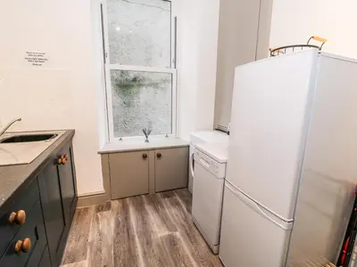 a kitchen with a white refrigerator and a window at Sapphire Suite in Barmouth