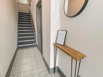 a hallway with a staircase and a mirror on the wall at Sapphire Suite in Barmouth