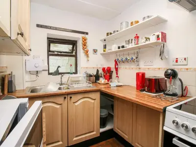 a kitchen with wooden cabinets and a counter top at The Wheelhouse at Dudgeley Mill in Church Stretton