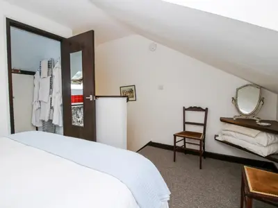 a bedroom with a bed and a mirror and a chair at The Wheelhouse at Dudgeley Mill in Church Stretton
