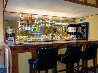 a bar with three bar stools in front of it at Riverbank Bed and Breakfast in Llanwrtyd Wells