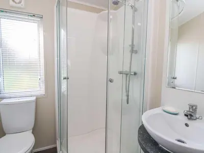 a bathroom with a shower and a toilet and a sink at The Potting Shed in New Quay