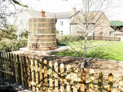 a fence in front of a house with a silo at The Cider House in Leominster