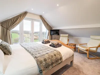 a bedroom with two beds and a large window at Hen Dy Bryn Mawndy in Corwen