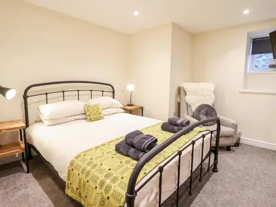 a bedroom with a bed and a chair at Hen Dy Bryn Mawndy in Corwen