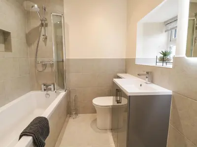 a bathroom with a sink and a toilet and a bath tub at Hen Dy Bryn Mawndy in Corwen
