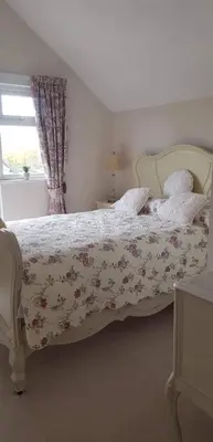 a bedroom with a bed with a floral bedspread at Lavender Cottage in Presteigne