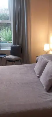 a bedroom with a bed with a window and a lamp at 2 Bodwen Villas in Llangollen
