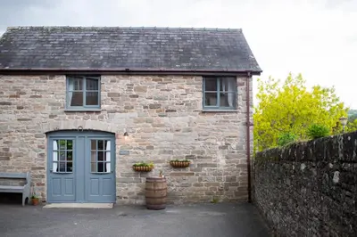 a brick house with a blue door and a bench at The Old Cider House in Hay-on-Wye