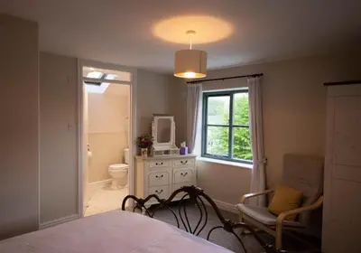 a bedroom with a bed and a toilet and a window at The Old Cider House in Hay-on-Wye