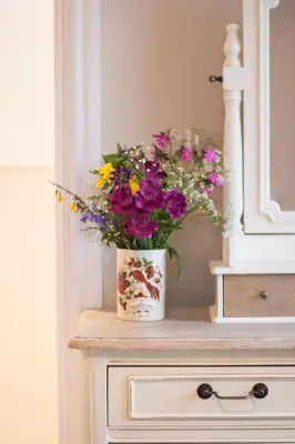 a vase of flowers sitting on top of a dresser at The Old Cider House in Hay-on-Wye
