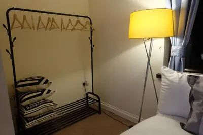 a bedroom with a bed and a lamp and towels at 15 Bronant in Talgarth