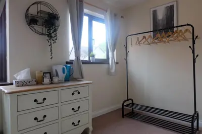 a bedroom with a white dresser and a window at 15 Bronant in Talgarth