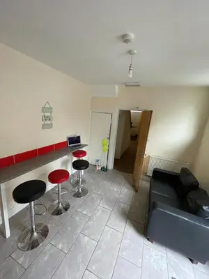 a living room with a couch and two bar stools at 52 Cambrian St in Aberystwyth