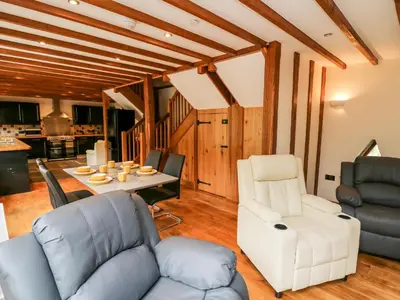 a living room with a couch and a table and chairs at Ploony Barn in Bleddfa