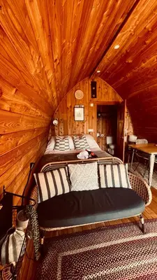a bedroom with a bed in a wooden room at Hillside hideaway - Hendre-Aur Pod in Machynlleth