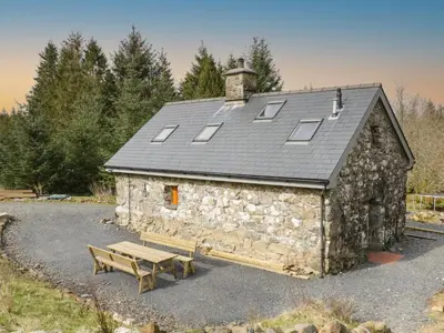 a stone building with a bench in front of it at Brithgwm Canol in Dolgellau