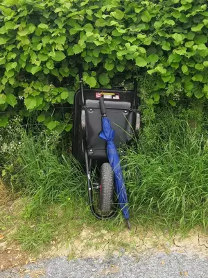 a blue umbrella sitting in the grass next to a television at Y Cwtch in Trefeglwys