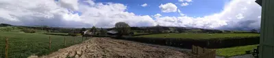a dirt field with a fence and sheep in a field at Y Cwtch in Trefeglwys