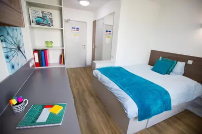 a small bedroom with a bed and a desk at Fferm Penglais Apartments in Aberystwyth