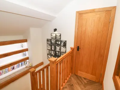 a staircase with a wooden door in a house at Bwthyn Bach Gwyn in Penrhyndeudreath