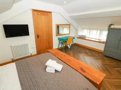 a room with a bed and a desk in it at Bwthyn Bach Gwyn in Penrhyndeudreath