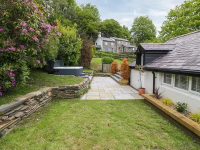 a backyard of a house with a stone pathway at Bwthyn Bach Gwyn in Penrhyndeudreath