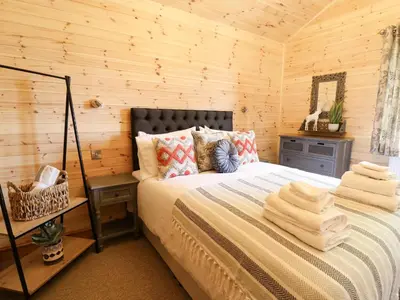 a bedroom with a bed in a log cabin at The Larches in Llanidloes
