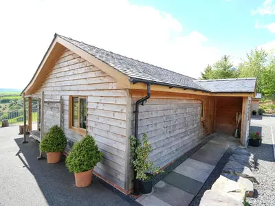 a building with potted plants in front of it at The Larches in Llanidloes