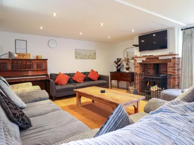 a living room with a couch and a piano at Bwthyn Y Bugail Shepherd's Cottage in Oswestry