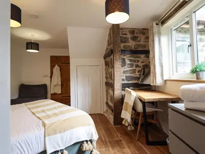 a bedroom with a bed and a desk and a window at Y Granar The Granary in Oswestry