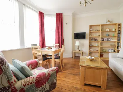 a living room with a couch and a table at The Nook in Tywyn
