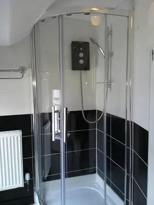 a shower with a glass door in a bathroom at The Crown Hotel in Corwen