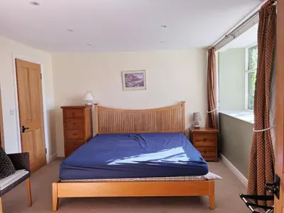 a bedroom with a bed with blue sheets and a window at The Crown Hotel in Corwen