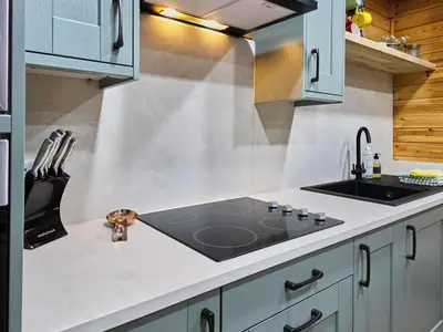 a kitchen with a stove and a sink at Luxury Wood Lodge with sauna, log burner & private woodland garden - Wnion Wood Lodge in Llanfachreth