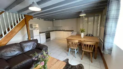 a living room with a couch and a wooden table at Crug Yr Eryr Isaf in Llandysul
