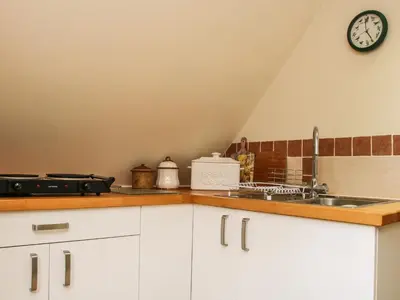 a kitchen with a sink and a clock on the wall at Milford Tree Tops in Craven Arms
