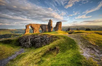 an old stone house on a grassy hill at Fern Studio 1 Bedroom Apartment in Llangollen