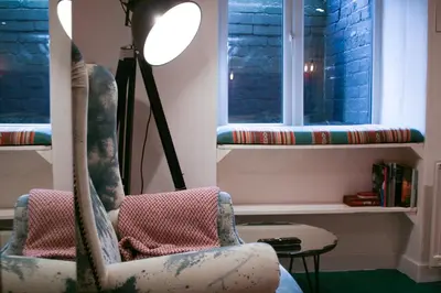 a room with two chairs and a table and windows at Fern Studio 1 Bedroom Apartment in Llangollen